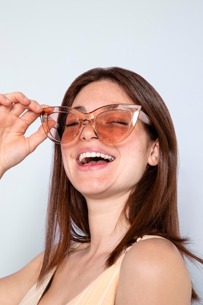 Gros plan femme heureuse, lunettes de soleil