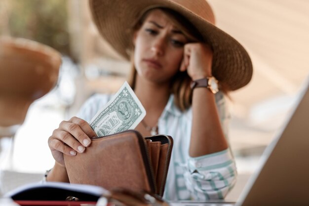 Gros plan d'une femme inquiète ayant un billet d'un dollar dans son portefeuille