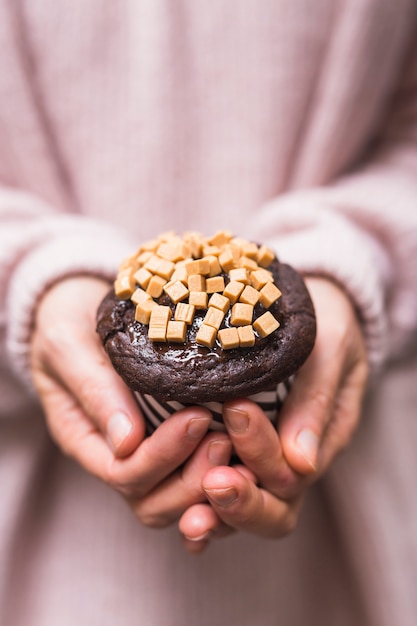 Photo gratuite gros plan, de, femme, mains, tenue, coupe, gâteau, à, caramel, bonbons, toppings