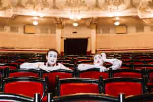 Photo gratuite gros plan, femme, mâle, mime, séance, bras, fauteuil, auditorium