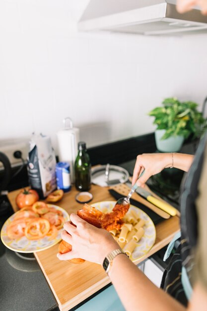 Gros plan, de, femme, mettre, pâtes, sauce, de, pot