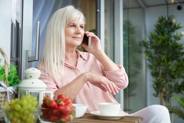 Gros plan sur femme mûre bénéficiant d'un bon café sur le balcon