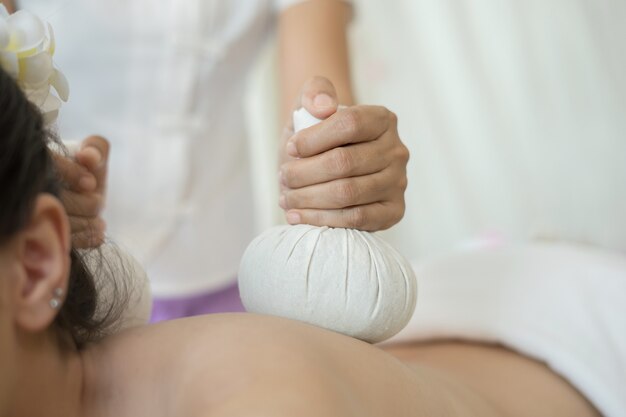 Gros plan d&#39;une femme pendant le massage des balles dans un salon de spa.