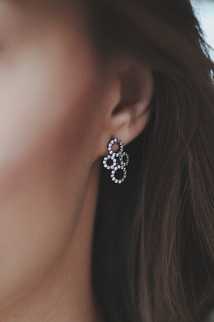 Photo gratuite gros plan d'une femme portant une belle boucle d'oreille pendentif