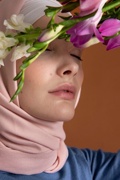 Gros plan femme posant avec des fleurs