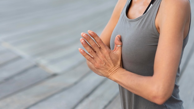 Gros plan femme pratiquant le yoga avec les mains jointes