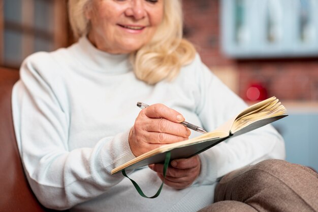 Gros plan femme senior écrit dans l'ordre du jour