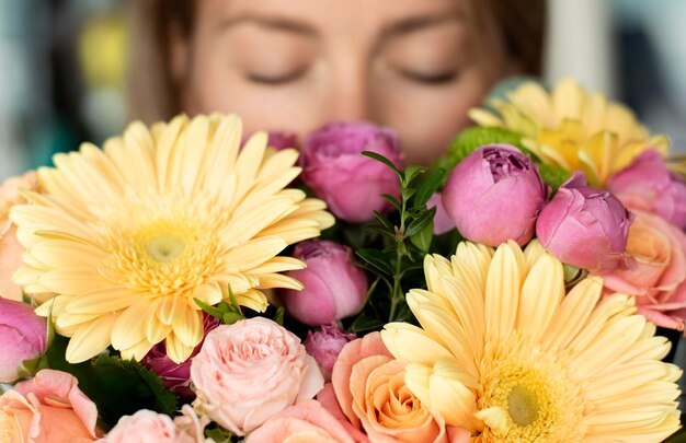 Gros plan femme sentant des fleurs