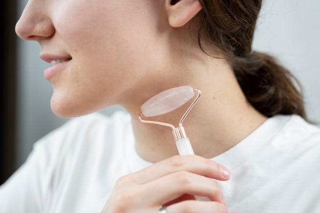 Gros plan femme souriante à l'aide de l'outil visage