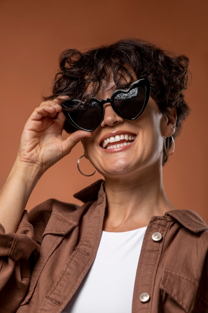 Gros plan femme souriante portant des lunettes de soleil