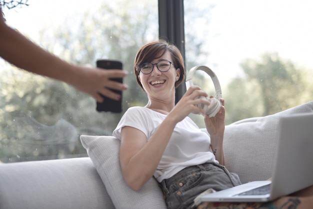 Gros plan d'une femme souriante regardant un téléphone dans les mains d'une personne