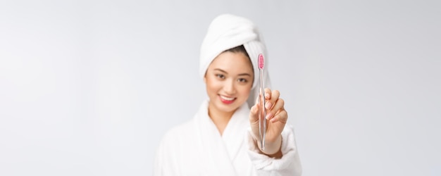 Gros plan sur une femme souriante se brosser les dents idéale pour le concept de soins dentaires de santé isolé sur fond blanc asiatique