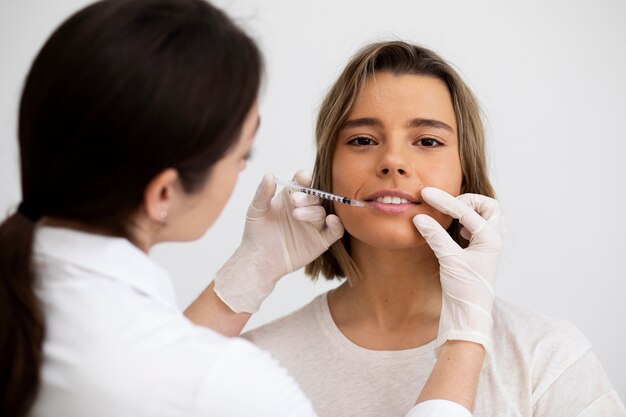 Gros plan femme souriante se remplissant les lèvres