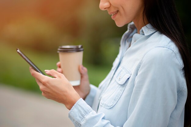 Gros plan femme souriante tenant le téléphone