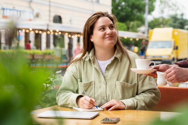 Gros plan femme souriante à la terrasse