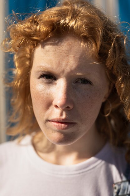 Gros plan femme avec des taches de rousseur en regardant la caméra