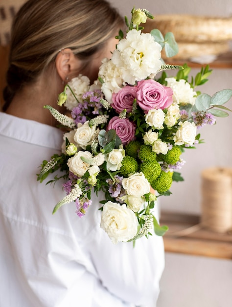 Gros plan femme tenant un bouquet de fleurs