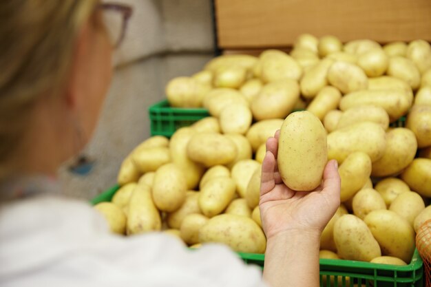 Gros plan de femme tenant la pomme de terre dans la main