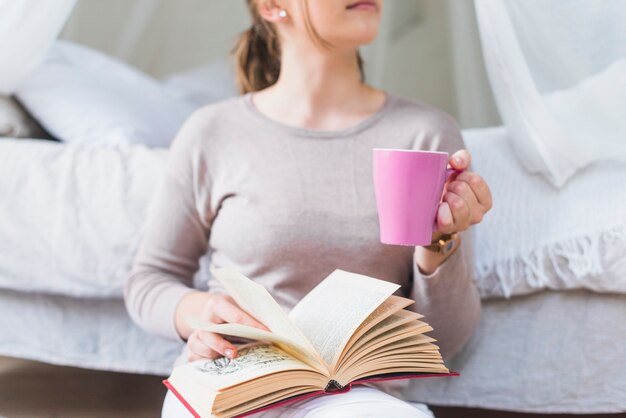 Gros plan, femme, tenue, café, tasse, livre