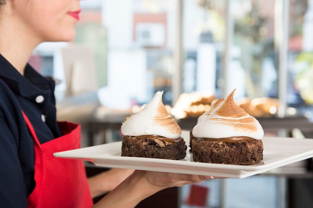 Gros plan, de, femme, tenue, plateau, de, délicieux gâteau, à, blanc, fouetté