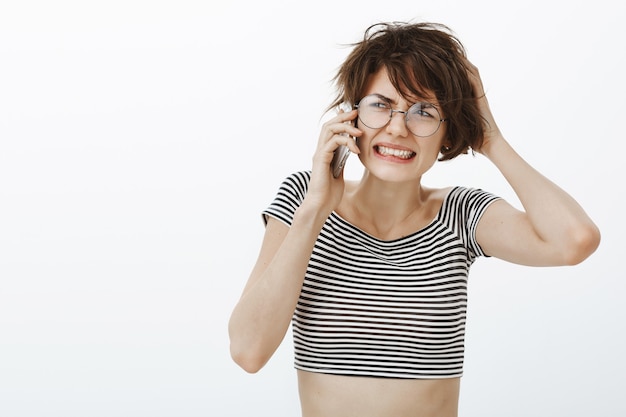 Gros plan d'une femme troublée et bouleversée entendre de mauvaises nouvelles sur le téléphone, se sentir dérangé