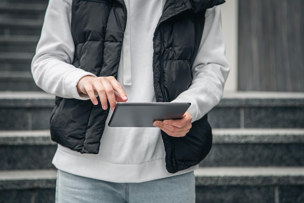 Gros plan une femme utilise une tablette à l'extérieur