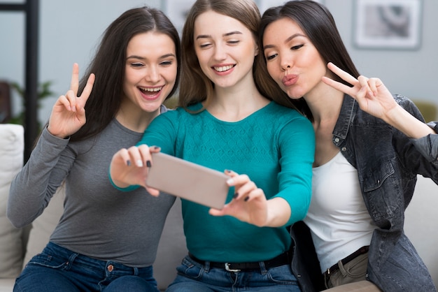 Gros plan des femmes adultes prenant un selfie ensemble