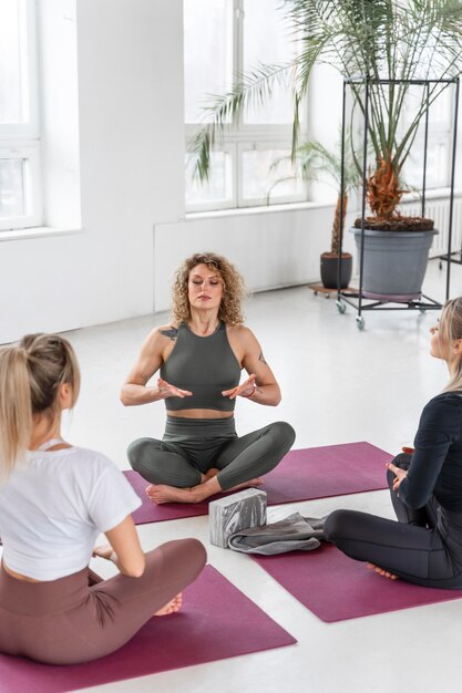 Gros plan des femmes faisant du yoga à l'intérieur