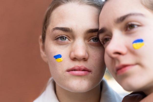 Photo gratuite gros plan des femmes avec de la peinture de drapeaux ukrainiens