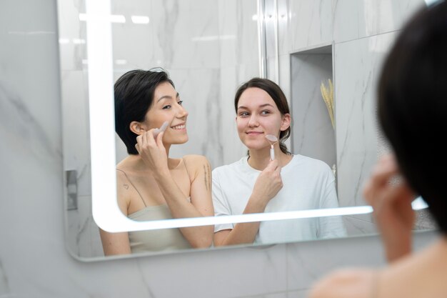 Gros plan des femmes souriantes regardant dans le miroir