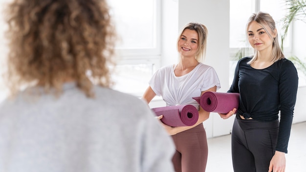 Photo gratuite gros plan des femmes tenant un tapis de yoga