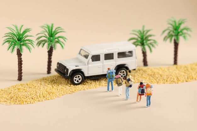 Photo gratuite gros plan sur des figurines jouets d'une famille en voyage près d'une voiture