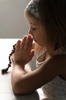Gros plan fille chrétienne priant avec crucifix