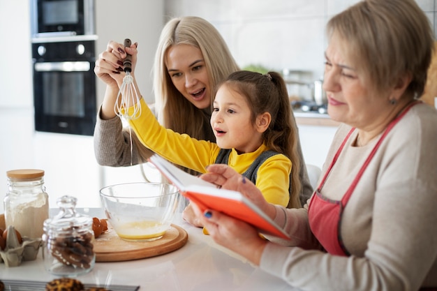 Gros plan sur une fille cuisinant avec sa mère et sa grand-mère