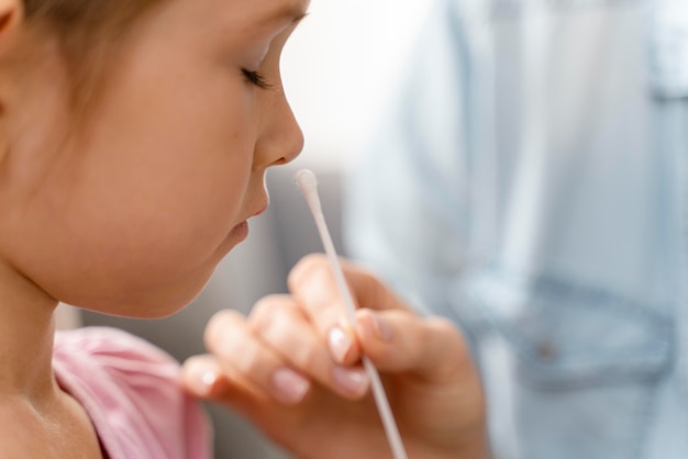 Gros plan sur une fille faisant un test de covid à domicile