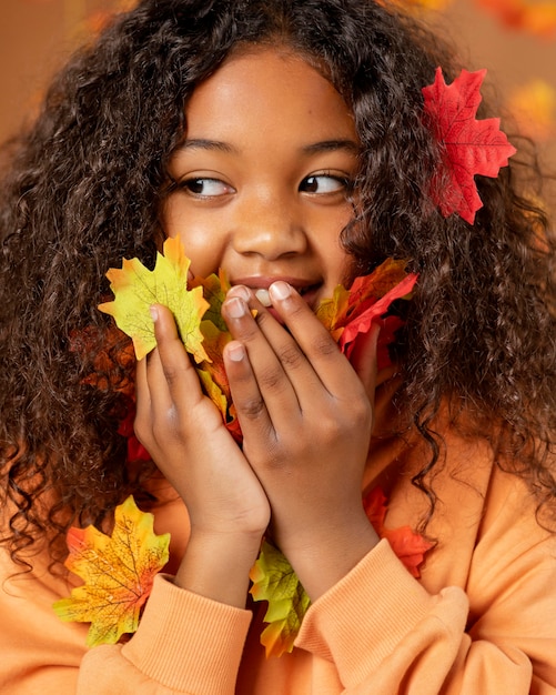 Photo gratuite gros plan fille avec des feuilles colorées