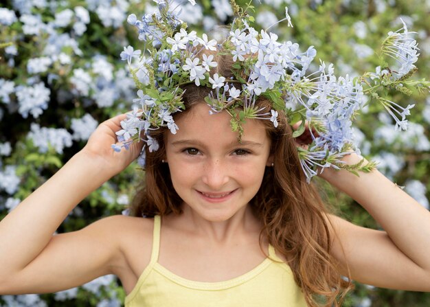 Gros plan fille posant avec des fleurs