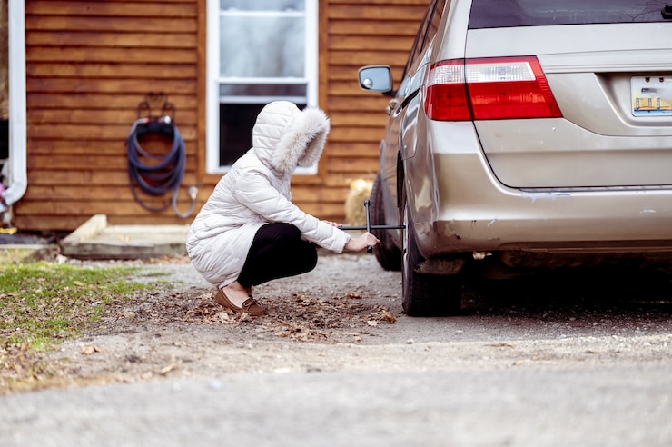 Photo gratuit gros plan d'une fille réparant une roue de voiture