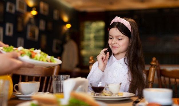 Gros plan fille smiley à table