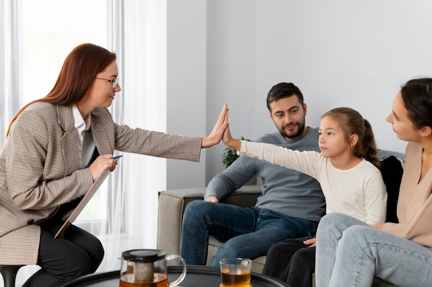 Gros plan fille et thérapeute high five