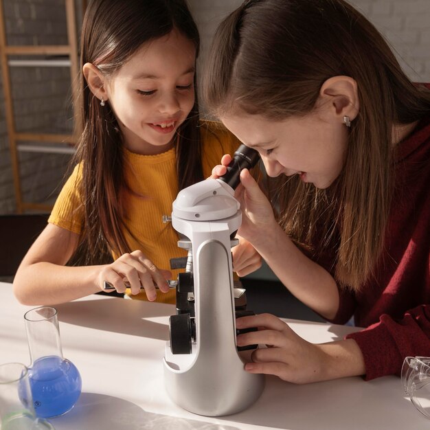 Gros plan des filles travaillant au microscope