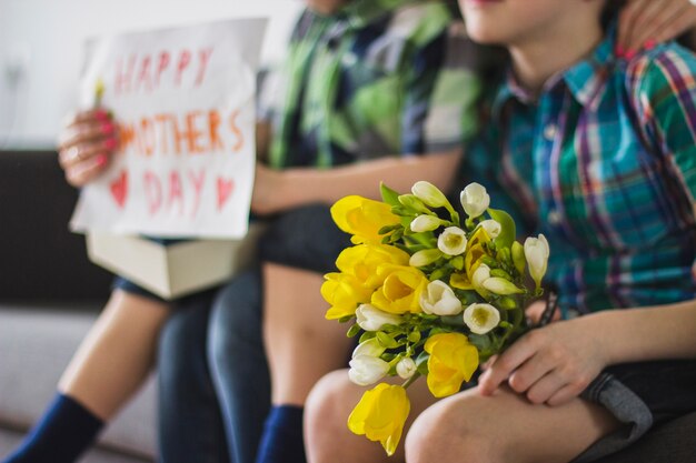 Gros plan de garçon avec bouquet pour sa mère