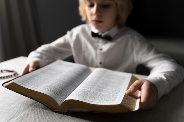 Gros plan garçon chrétien lisant la bible