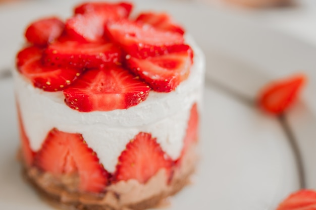 Gros plan de gâteau aux fraises avec fraises fraîches sur fond de bois. Gâteau fraise maison. Cheesecake à la fraise