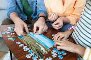 Photo gratuite gros plan des gens faisant des puzzle ensemble