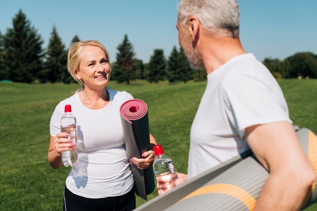 Gros plan des gens avec des tapis de yoga en plein air