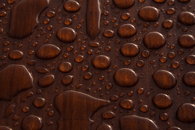 Photo gratuite gros plan de gouttes d'eau sur une surface en bois