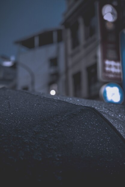 Gros plan des gouttes de pluie sur un parapluie