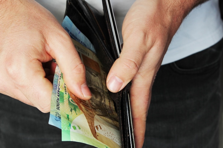 Photo gratuit gros plan grand angle d'une personne mettant de l'argent dans un portefeuille en cuir