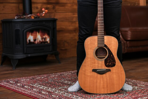 Gros plan guitare acoustique sur le tapis